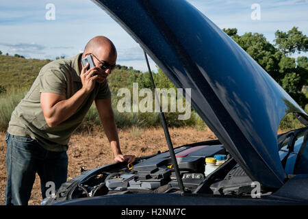 Close up of a broken down car, moteur ouvert, dans une zone rurale et le pilote à la recherche sur le moteur Banque D'Images