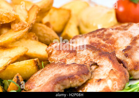 Close up de pommes de terre frites et de porc rôti. Banque D'Images