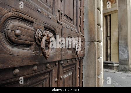 Vieille porte en bois, pierre et heurtoirs de porte fait-post. Banque D'Images