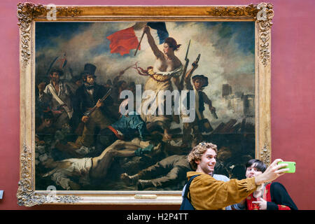 Couple qui en selfies avant de la liberté guidant le peuple, Louvre, Paris Banque D'Images