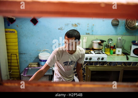 Un jeune travailleur restaurant - le chef est la préparation des aliments dans la cuisine. Santiago de Cuba, Cuba. Banque D'Images