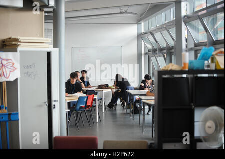 Des étudiants d'obtenir leur tête en bas et travailler dur sur leurs études dans un collège de classe. Banque D'Images