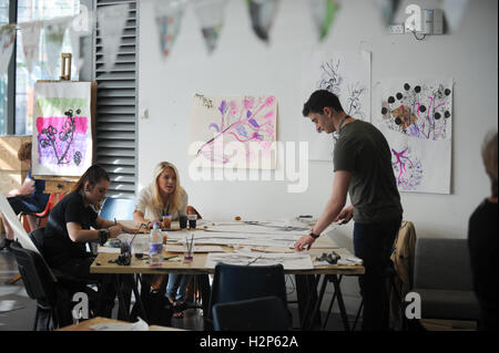 Les étudiants du collège apprécie de travailler dans une salle de classe sur un projet de design de façon détendue. Banque D'Images