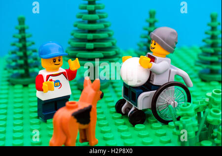 Tambov, Fédération de Russie - 30 juillet, 2016 en fauteuil roulant garçon Lego jouer au ballon avec son ami et le chien dans le parc. Studio shot. Banque D'Images