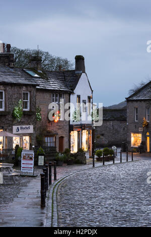 Lumières de Noël coloré égayer une sombre soirée d'hiver - Malham Village, Yorkshire Dales National Park, England. Banque D'Images