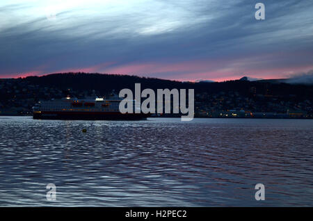 Hammerfest, NORVÈGE - 29 septembre 2016 : l'express côtier norvégien Hurtigruten, laissant Tromsoe, ville au coucher du soleil Banque D'Images