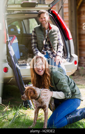 Portrait femme enthousiaste avec chien extérieur Banque D'Images