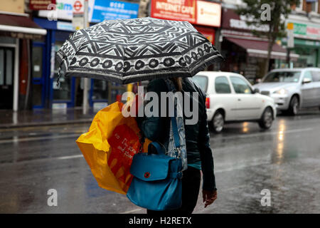 Le nord de Londres, Royaume-Uni. 06Th Oct, 2016. Météo britannique. Les gens à l'abri de la pluie dans le nord de Londres. Credit : Dinendra Haria/Alamy Live News Banque D'Images