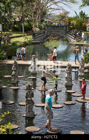 L'INDONÉSIE, Bali, Tirta Gangga, les touristes sur l'eau jardin stepping stones Banque D'Images