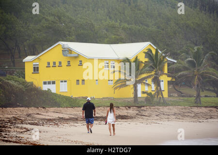 La Barbade côte atlantique barclays park lakes Beach grande maison jaune dog walkers sable couleur couleur lumineux de marche en vous promenant sa Banque D'Images