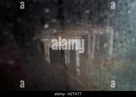 À la fermeture dans un restaurant avec la pluie sur la fenêtre et vide de tables et de chaises. Banque D'Images