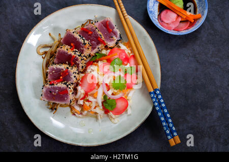 Thon poêlé en croûte de graines de sésame avec salade asiatique épicée et radis marinés Banque D'Images