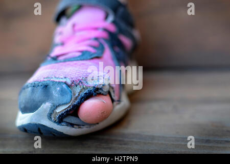 Vieilles chaussures avec des trous pour les sans-abri miteux usé orteils qui sort de l'habillement Banque D'Images