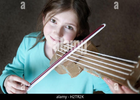 Jeune fille jouant du violon jouet smiling happy Banque D'Images