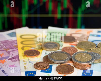 Billets et pièces en euro sur l'arrière-plan du graphique. Banque D'Images