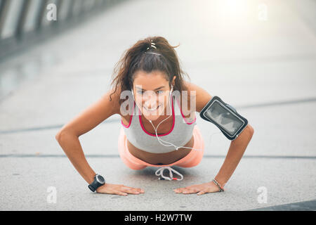 Portrait d'une belle jeune femme faisant des pousées sur rue Banque D'Images