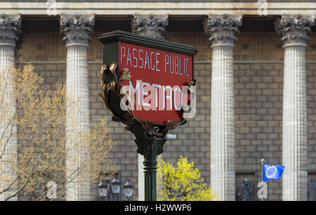 Le métro de Paris rouge signe et l'église de la Madeleine à l'arrière-plan, Paris, France. Banque D'Images