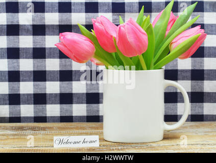 Bienvenue accueil carte avec des tulipes roses dans la tasse à café blanche Banque D'Images