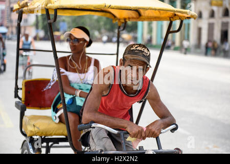 La conduite de l'homme cubains pedicab avec passager à Santiago de Cuba, Cuba. Banque D'Images