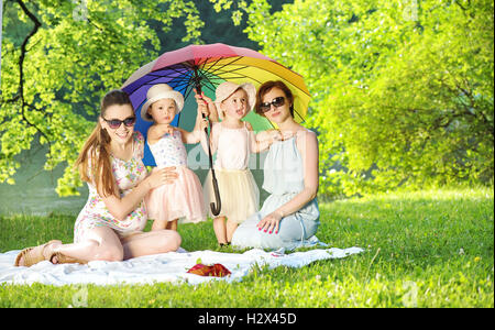 Jolies femmes et petites filles en appui sur la couverture bleue Banque D'Images