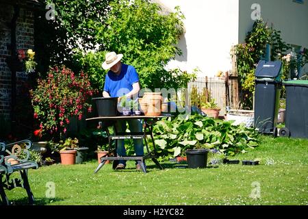 Les plantes en pot résident local en dehors de son chalet, Milton Abbas, Dorset, Angleterre, Royaume-Uni, Europe de l'Ouest. Banque D'Images