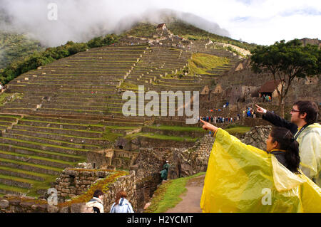 Les touristes à l'intérieur du complexe archéologique de Machu Picchu. Machu Picchu est une ville d'altitude dans les montagnes des Andes dans modern Banque D'Images