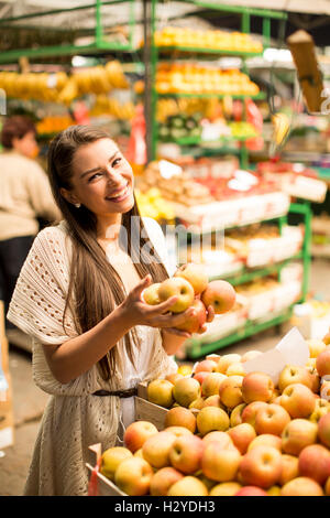 Jolie jeune femme l'achat des pommes sur le marché Banque D'Images