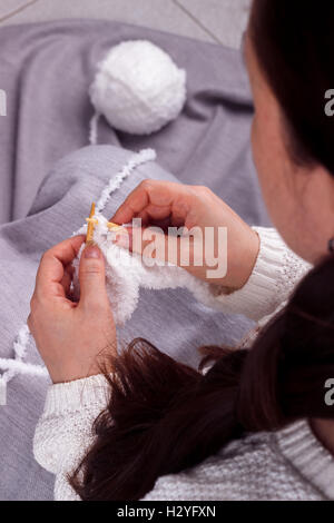 Close up of woman mains blanc fil de laine à tricoter. Banque D'Images