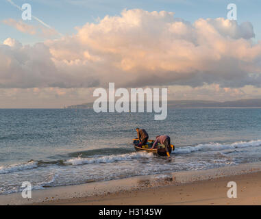 Deux pêcheurs de sortir dans une barque, au large de la plage de Bournemouth, à pêcher dans la baie de Poole, Dorset, UK Banque D'Images