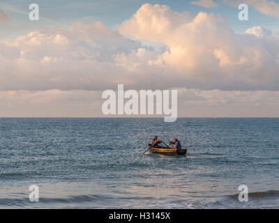 Deux pêcheurs de sortir dans une barque, au large de la plage de Bournemouth, à pêcher dans la baie de Poole, Dorset, UK Banque D'Images