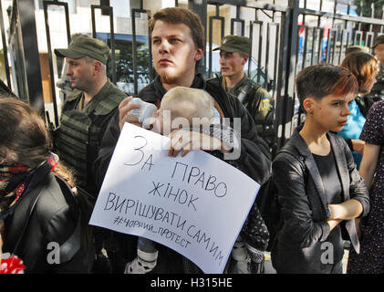 Kiev, Ukraine. 3e oct, 2016. Un manifestant ukrainien avec un enfant prend part au rassemblement pour soutenir la grève des femmes polonaises à l'échelle nationale, en face de l'ambassade de Pologne à Kiev, Ukraine, le 03 octobre, 2016. La grève est une expression de l'opposition pour renforcer les règlements sur la loi sur l'avortement. Credit : ZUMA Press, Inc./Alamy Live News Banque D'Images