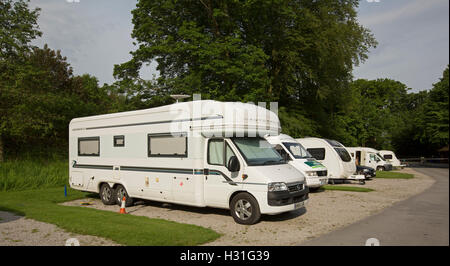 Groupe des motorhomes et caravanes garées entre paysage dominé par l'ombrage des arbres à Bolton Abbey Caravan Park en Angleterre Banque D'Images