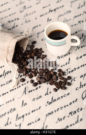 Heap coffe beans et tasse de café frais sur serviette décorative Banque D'Images