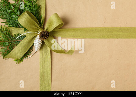 Close up of arc et des décors naturels sur les cadeaux de Noël. Cadeau de Noël enveloppé dans du papier d'emballage recyclé. Banque D'Images