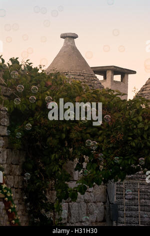 Trulli à Alberobello avec des bulles de savon au coucher du soleil Banque D'Images