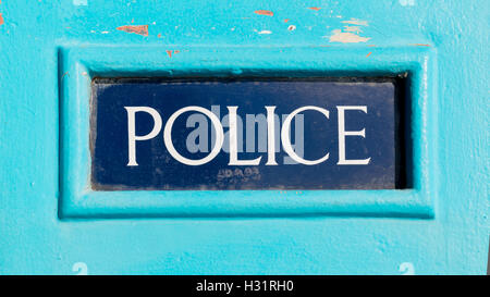 Signe de la police britannique traditionnel écrit sur fond bleu foncé sur une boîte de police en bois bleu clair Banque D'Images