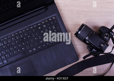À plat à l'image d'un ordinateur portable et appareil photo sur une surface en bois Banque D'Images