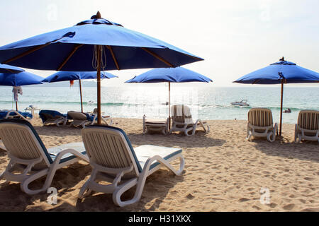 Chaises longues bleu sous un parasol sur la mer d'Andaman en Thaïlande Banque D'Images