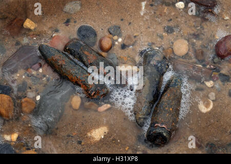 Passé la seconde guerre mondiale, deux obus de 20 millimètres dans le sable humide sur une plage. Banque D'Images