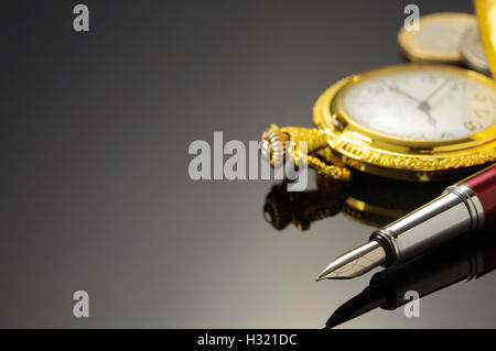 Montre de poche et stylo à encre sur fond noir Banque D'Images