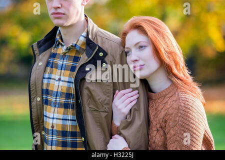 Jeune couple en train de marcher à travers un champ en automne. Banque D'Images