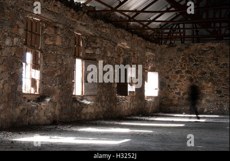 Creepy abandonnés vide chambre d'hôtel avec soleil entrant dans la fenêtres et un ghost walking Banque D'Images