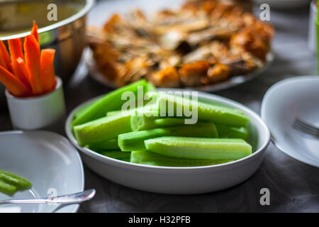 Couper des morceaux de concombre et de carottes dans une assiettes en porcelaine sur une table Banque D'Images