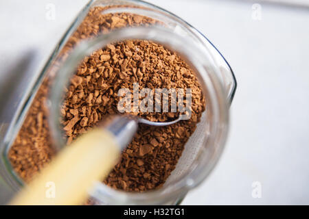 Une cuillère dans un pot de café instantané granules. Banque D'Images