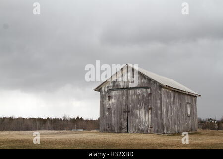 Grange rustique avec de sombres nuages en arrière-plan Banque D'Images