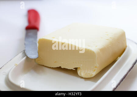 Le beurre frais de la ferme de Pat sur un beurrier avec un couteau Banque D'Images