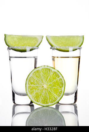 L'argent et l'or verre à tequila lime slice on white background Banque D'Images