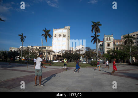 Les adolescents cubains jouent au football dans le soleil en début de soirée dans une des nombreuses places de La Havane La Habana Cuba Banque D'Images