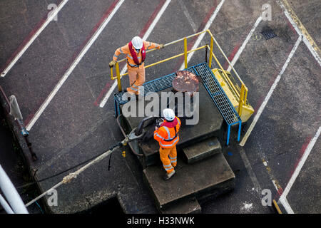 Les dockers du navire amarré hawser à shoreside bitt à quai du port Banque D'Images