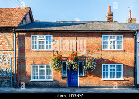 Maison en briques avec des paniers suspendus autour de la porte dans la rue historique vendredi, Henley on Thames, Oxfordshire, UK Banque D'Images